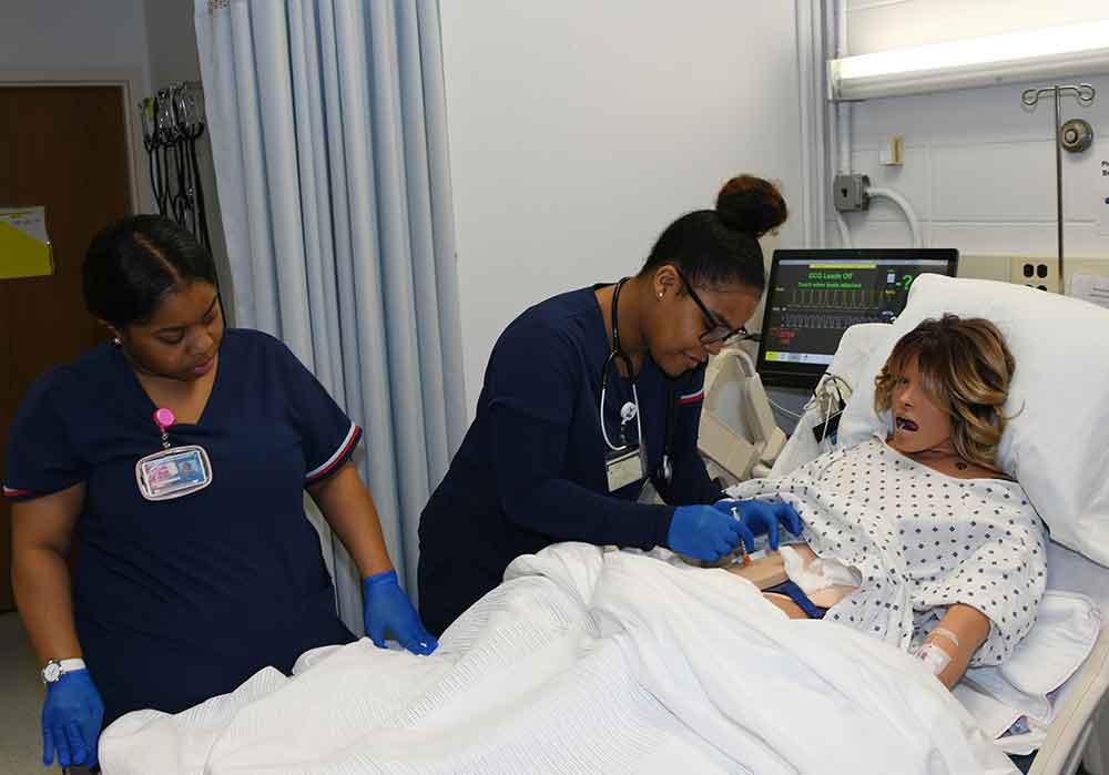 (L-r) Maya Taylor and Oforiwah Awuah learn their profession in the high-tech Nursing Lab. Such preparation has resulted in the reaffirmation of the accreditation for the University's Department of Nursing, which will be in force until 2027.