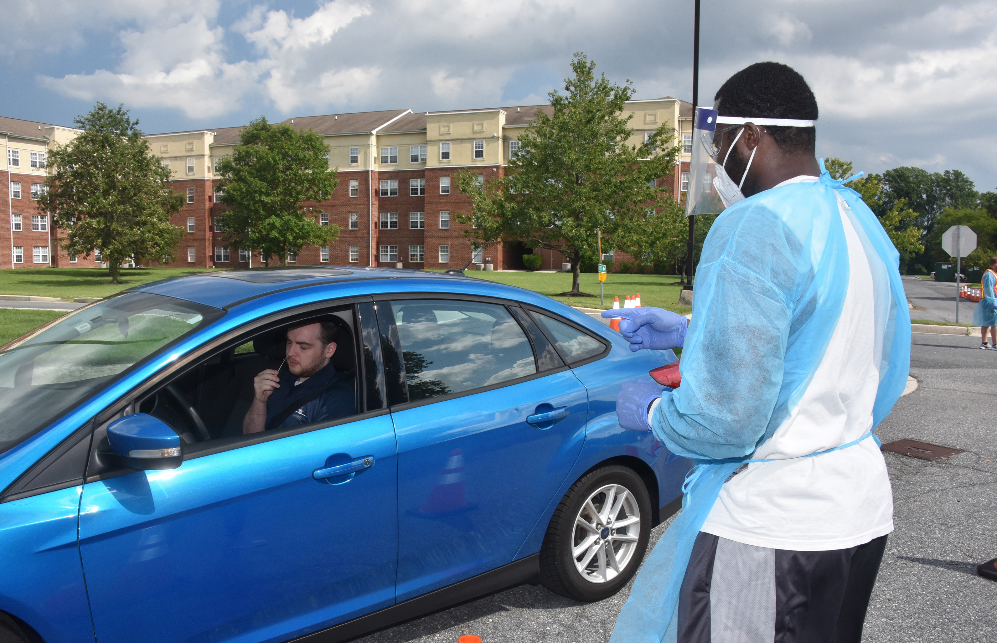 Dr. Derrick Scott (l), Assistant Professor of Biological Science, gives instruction to a University employee on how to administer the COVID-19 test to himself.