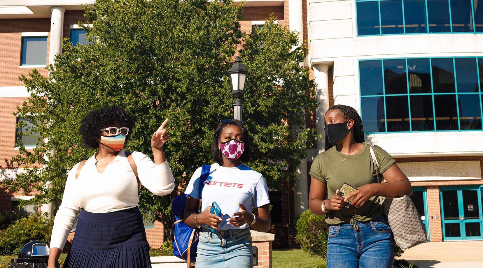 Returning students walking on campus wearing masks