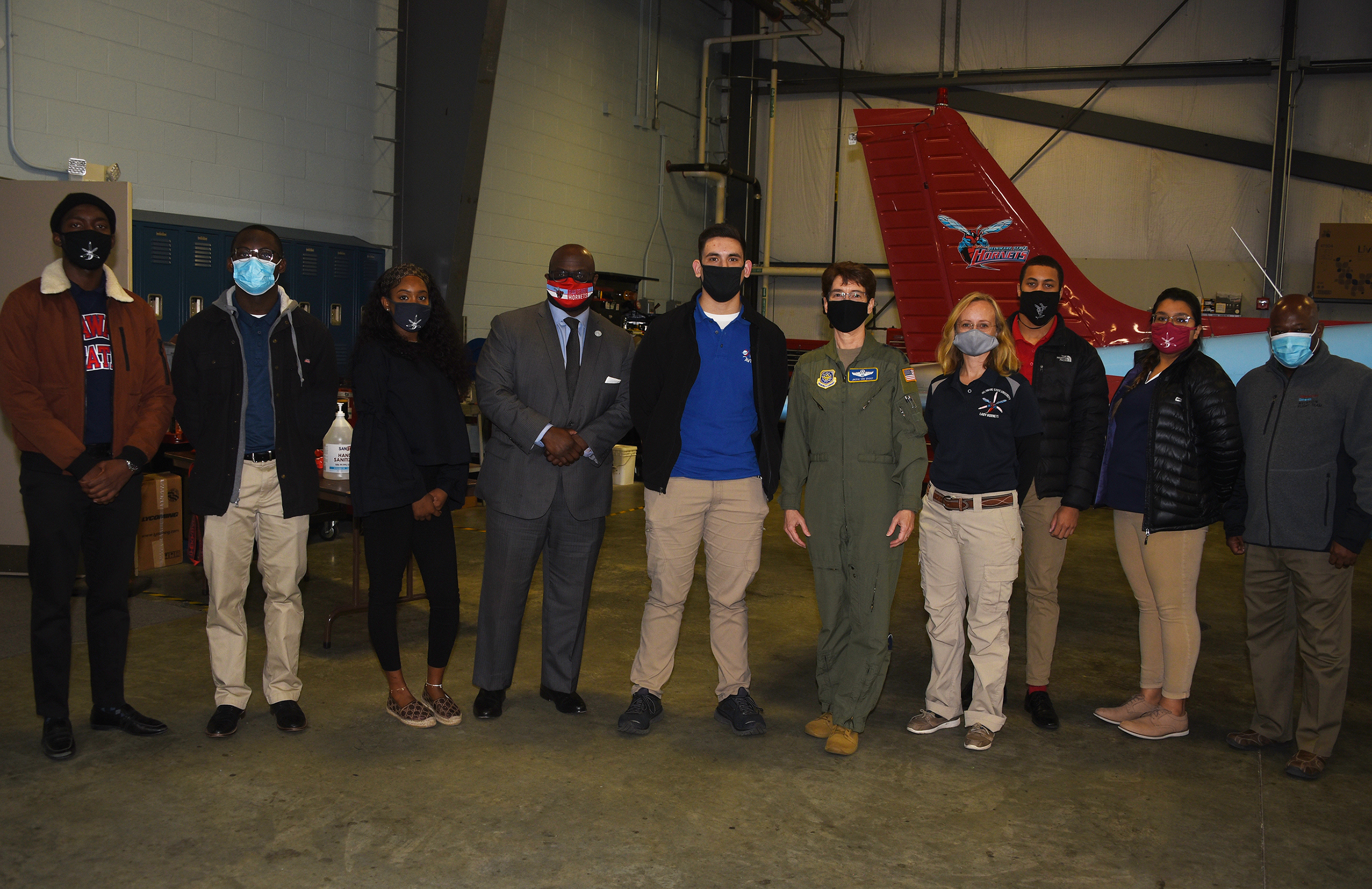 (L-r) Ian Teray Tcheliebou, Darrell Machison, Jalyn Clark, Dr. Tony Allen, Matthew Cunningham, Gen. Jacqueline D. Van Ovost, Cindy Blair, Mekhi Howard, Eliana Rothwell, and Aviation Program Director Lt. Col. (ret.) Michael Hales, pose for a photo after the four-star general gave an address at the Delaware Airpark