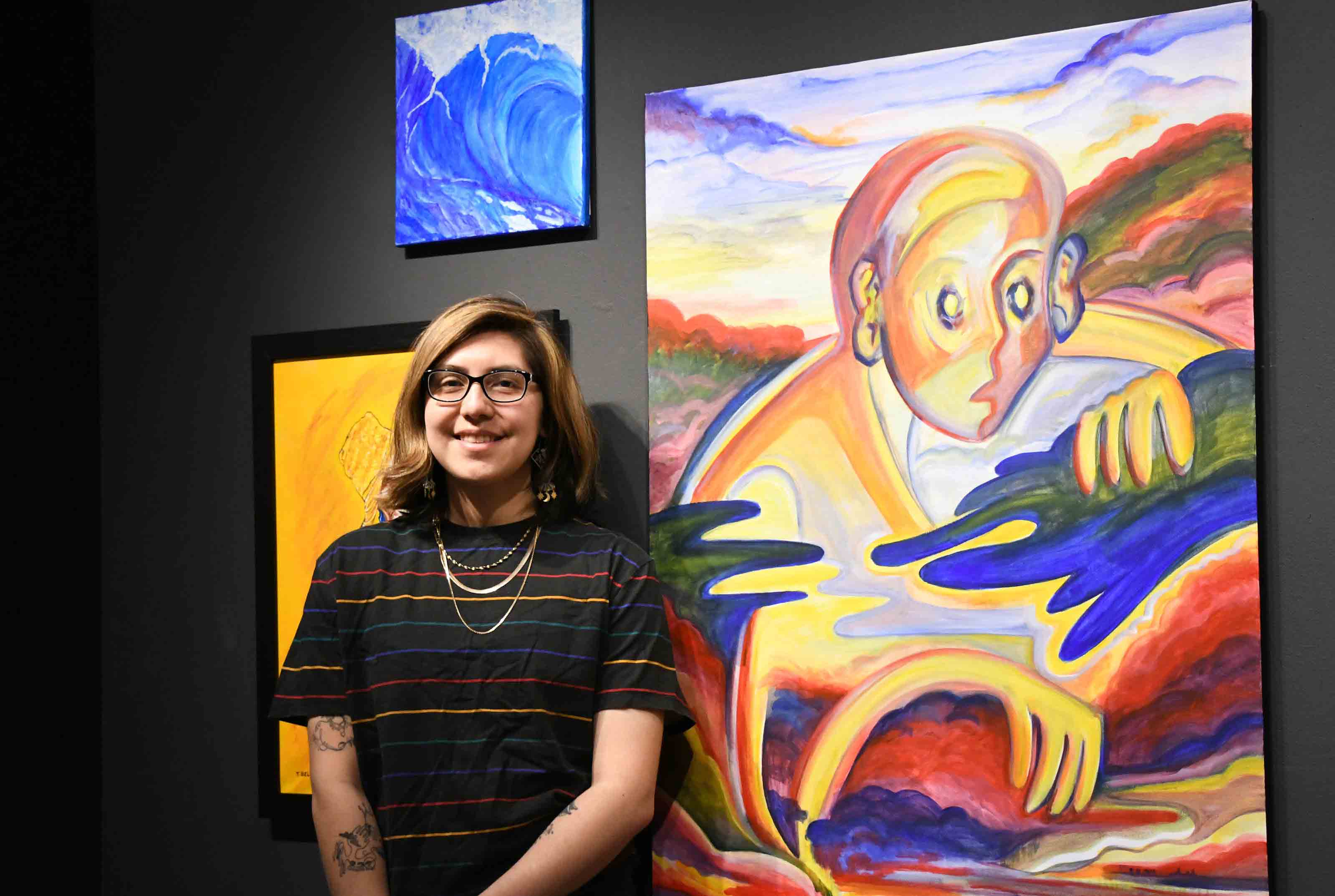 Kiara Florez stands next to her painting "The Wanderer," one of the works on display in the Creative Connections exhibition at the Arts Center/Gallery.