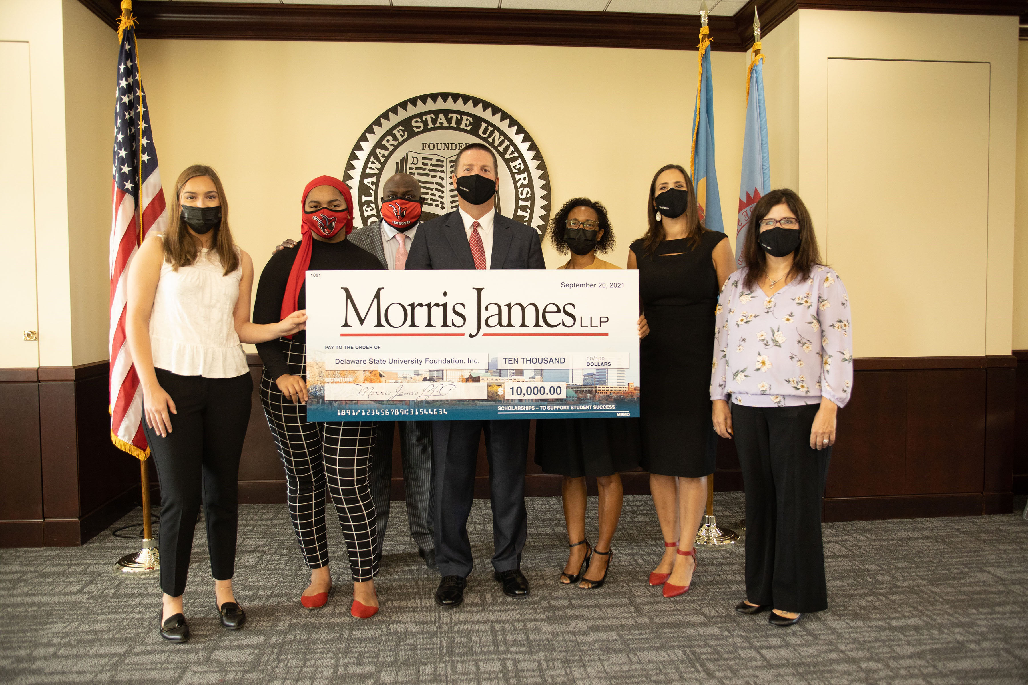 (L-r) Del State Law Studies students Emily Campanelli and Anissa Cartagenda, University President Tony Allen; Keith James, MJ Managing Partner; Patricia Winston, MJ Partner; Dawn Shaiker, MJ Client Relations Director; and Sherry Leary, MJ COO, all pose with a display check representing the law firm's donation in support of the University's Law Studies Program students.