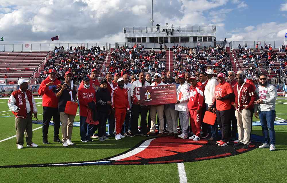 University President Tony Allen and brothers from his Kappa Alpha Psi fraternity take to the field during halftime of the Oct. 23 Homecoming game to present Del State with a check for $20,600. 