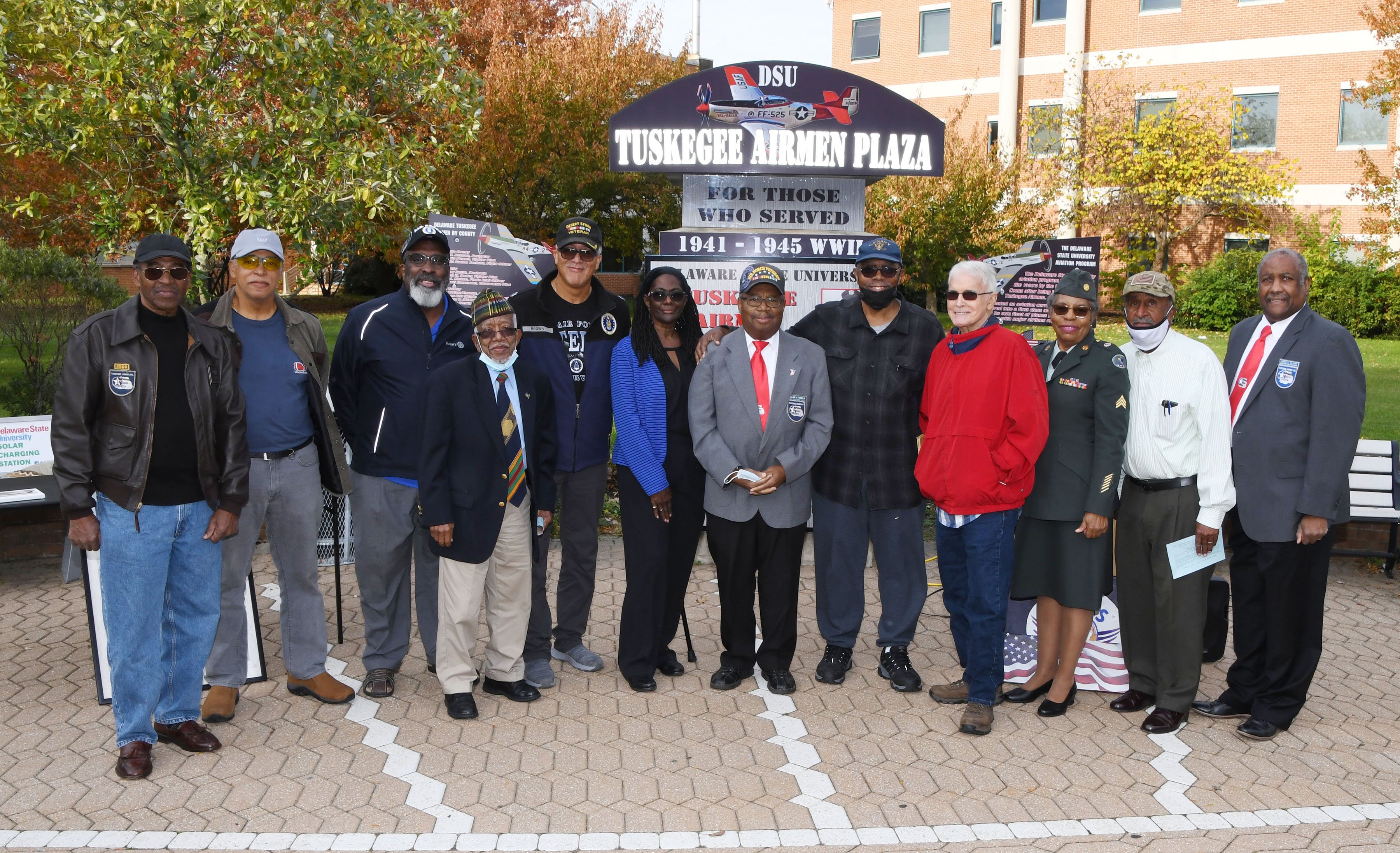 A group of veterans pose for a group shot after participating in a Veterans Day Program on the Tuskegee Airmen Plaza at Delaware State University