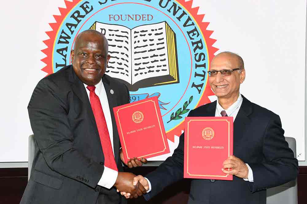 Tony Boyle, Vice President of Strategic Enrollment Management, and Dr. Binod Atreya, Managing Director/CEO of the Banking Finance & Insurance Institute of Nepal (BFIN), shake hands after signing a Letter of Intent that will open the door for the University to establish an MBA Certificate Program for that Institute.