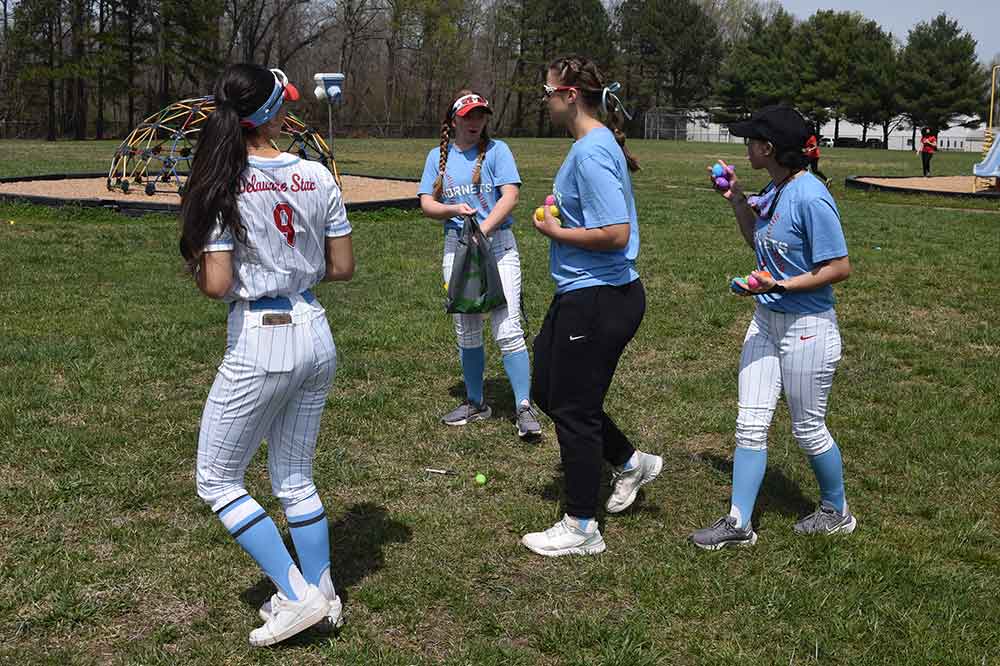 Member of the Lady Hornets softball team members go about the task of hiding Easter eggs during a DSU Downtown/Department of Athletics community service event at North Dover Elementary School.