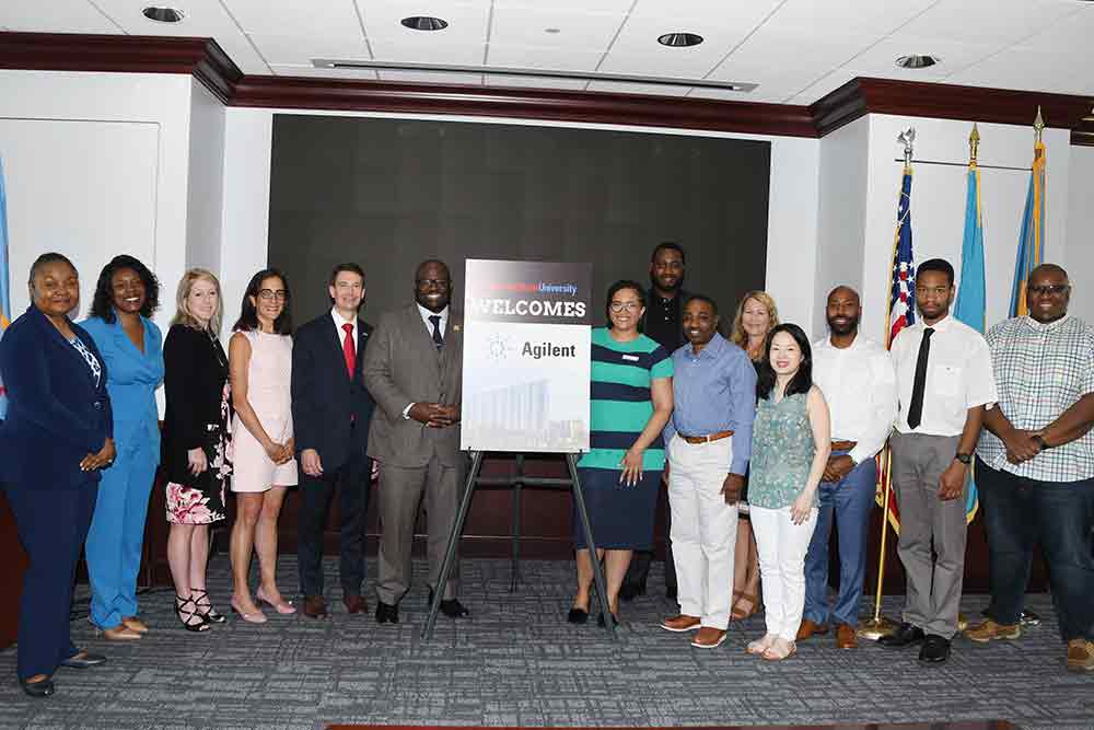 Representatives of Agilent, a laboratory technology company, pose with University President Tony Allen and other University officials during a June 10 visit on campus.