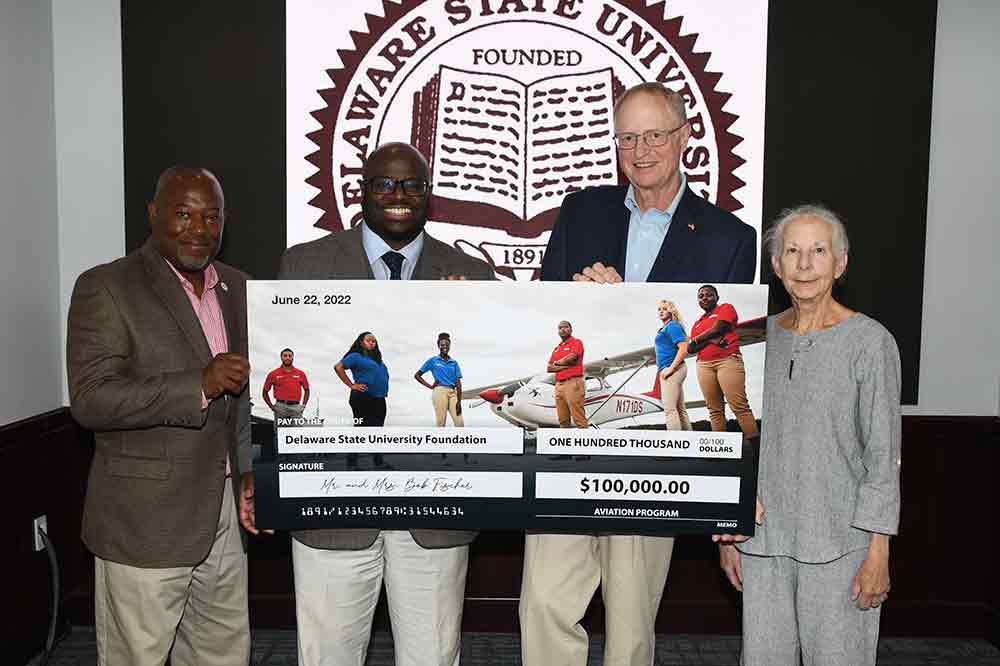 (L-r) Lt. Col (Ret.) Michael Hales, Aviation Program director, University President Tony Allen, along with Bob and Karen Fischer, hold a display check representing a $100,000 donation in support to the Aviation Program. The Fischer gift is the largest cash donation to the University's Aviation Program in its 36-years history.