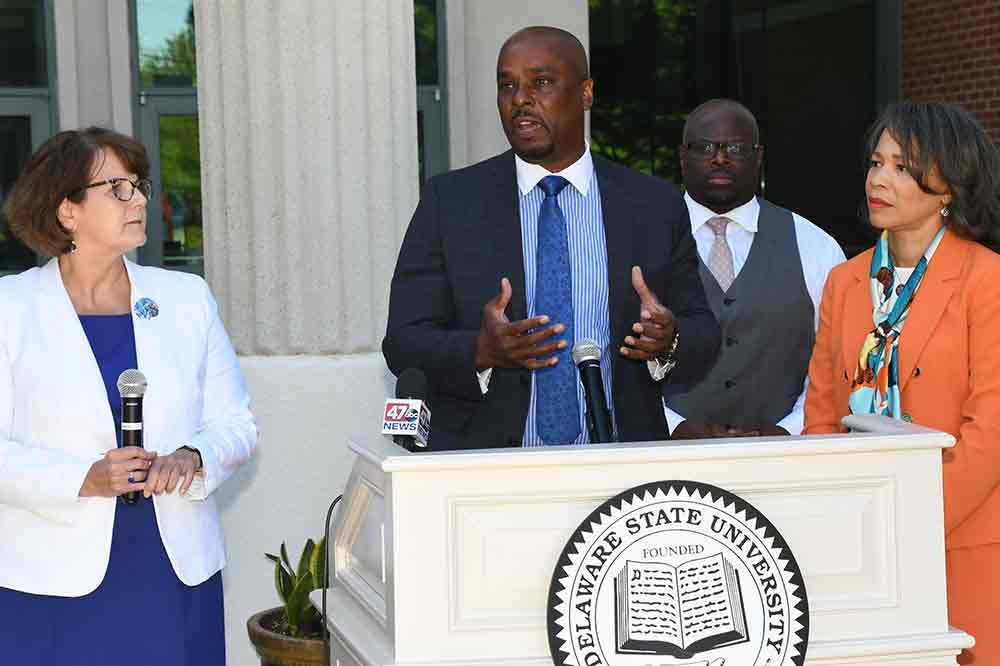 Dr. Michael Casson, Dean of the University's College of Business, explains how the CURE program will benefit the communities in Dover during a June 28 media event on campus. Flanking him are Karen Speakman, Executive Director of NCALL, University President Tony Allen, and Congresswoman Lisa Blunt Rochester.