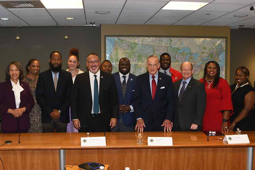 U.S. Secretary of Education Miguel Cardona (near center to left of University President Tony Allen) poses with the Congressional Delegation, University officials and students after a meeting at the DSU Riverfront in Wilmington to discuss the need for more male teachers of color.