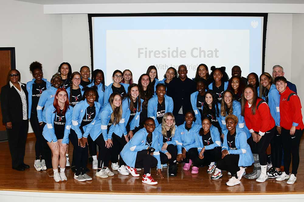 Ian Wright, English Football (Soccer) Hall of Fame star (center in black), poses with members of the University's women soccer team after sharing his sports career experiences during a Oct. 14 "fireside chat" in the Bank of America Building's Longwood Auditorium. 