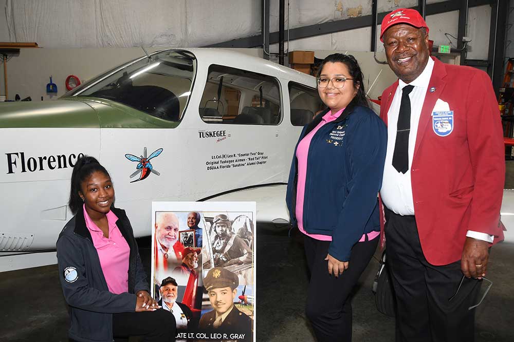 (L-r)  Aviation Program students Trinity Griffin and Eliana Rothwell pose with Arnold Nearn, President of the Florida Chapter of the DSUAA, as they stand with the Aviation Program's Piper Arrow aircraft that has been named after Lt. Col. Leo Gray, a Tuskegee pilot who flew missions during World War II.
