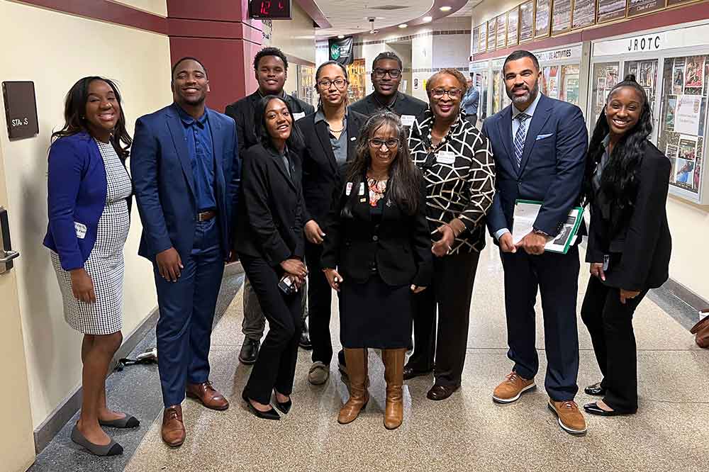 (L-r) Danielle Byrd-Thompson, Executive VP of Equitable Advisors; University students Omar Parker, Charles Pierce, Aaliyah Wilson, Tiffany Gray, Brian Williams; Dr. Nandita Das, Professor of Finance;  Dr. Marsha Horton, Special Assistant of University Office of Strategic Initiatives; Jarian Kerekes, Director of the Equitable Foundation; and University student Imani Washington pose for a picture during their visit to McKinley Technical High School.