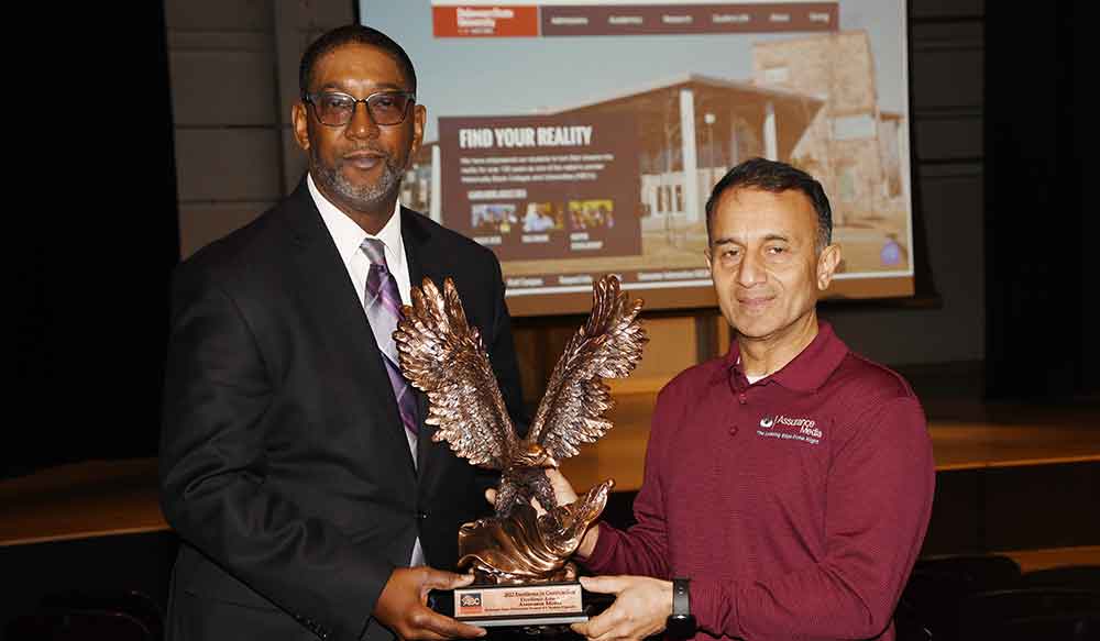 Darrell McMillon, the University's Chief Information Officer, receives on behalf of the University the 2022 Excellence in Construction Award from AJ Rahman, AV Practice Manager of Assurance Media, LLC. The award was presented in recognition of the renovation work done over the last year on the Education and Humanities Theatre.