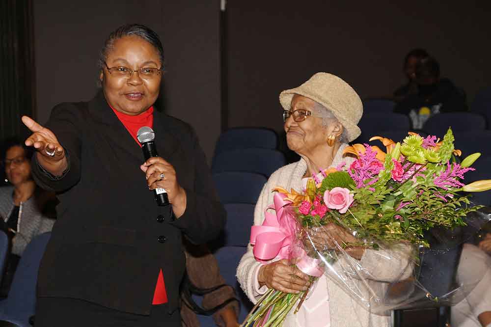 University Provost Saundra DeLauder speaks after presenting alumna Susan Young Browne with a large bouquet of roses at the end of a program that celebrated her almost 105-year-old life and hence her status as the oldest living alum at Delaware State University.