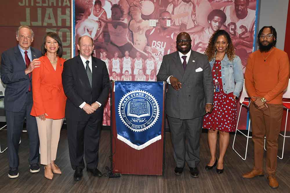 (L-r) U.S. Sen. Tom Carper, U.S. Rep. Lisa Blunt Rochester, U.S. Sen. Chris Coons, University President Tony Allen, Univ. Education Chair Shelly Rouser, and Darren Rainey, University Program Manager for Recruiting Diverse Educators, pose for a photo after the Delaware Congressional Delegation announced new federal funding totaling $1.68 million for Delaware State University during an April 24 media event.