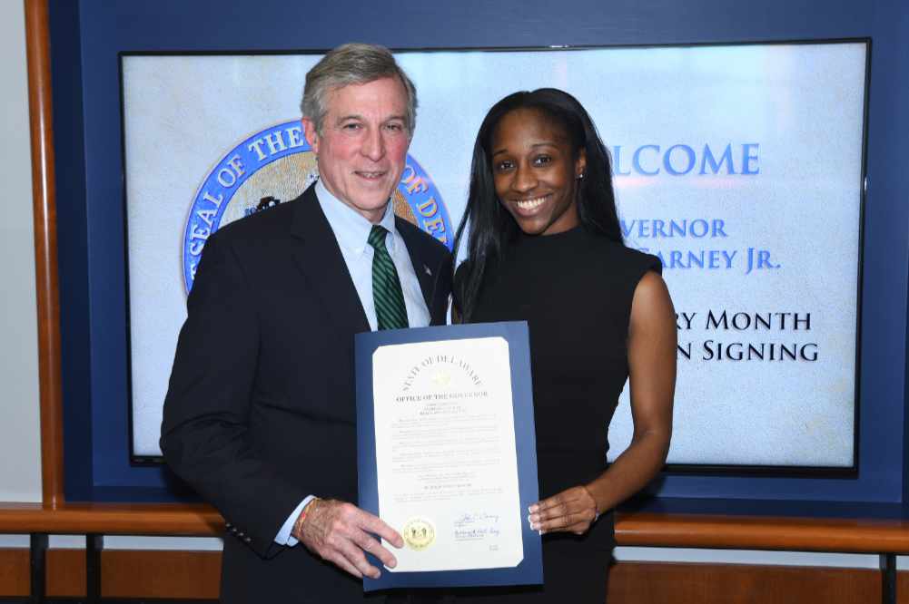 Gov. John Carney and DSU's Imani B. Washington hold the proclamation signed by the state's Chief Executive declaring February as Black History Month in Delaware. Ms. Washington gave an address during the ceremony.