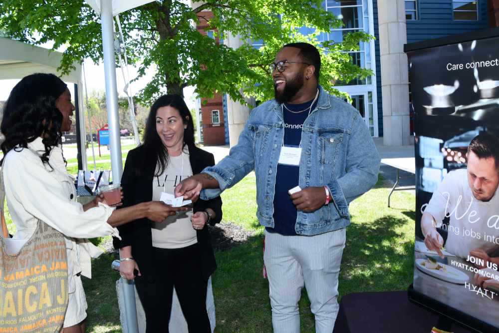 Representatives of Hyatt Hotels share their business cards with a DSU student during the April 16 Alliance for Hospitality, Equity and Diversity Campus Takeover, in which opportunities in the hospitality industry were shared with University students.