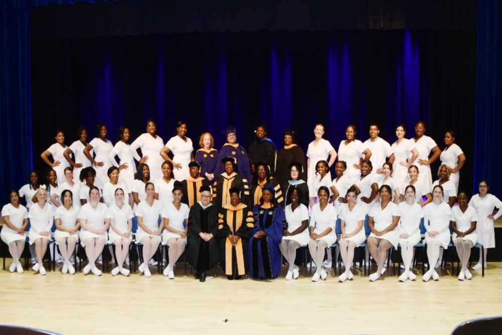 The 2024 Class of Nursing Graduate poses with faculty prior to the May 8 Nurse Pinning Ceremony in the William B. DeLauder Education and Humanities Theatre.