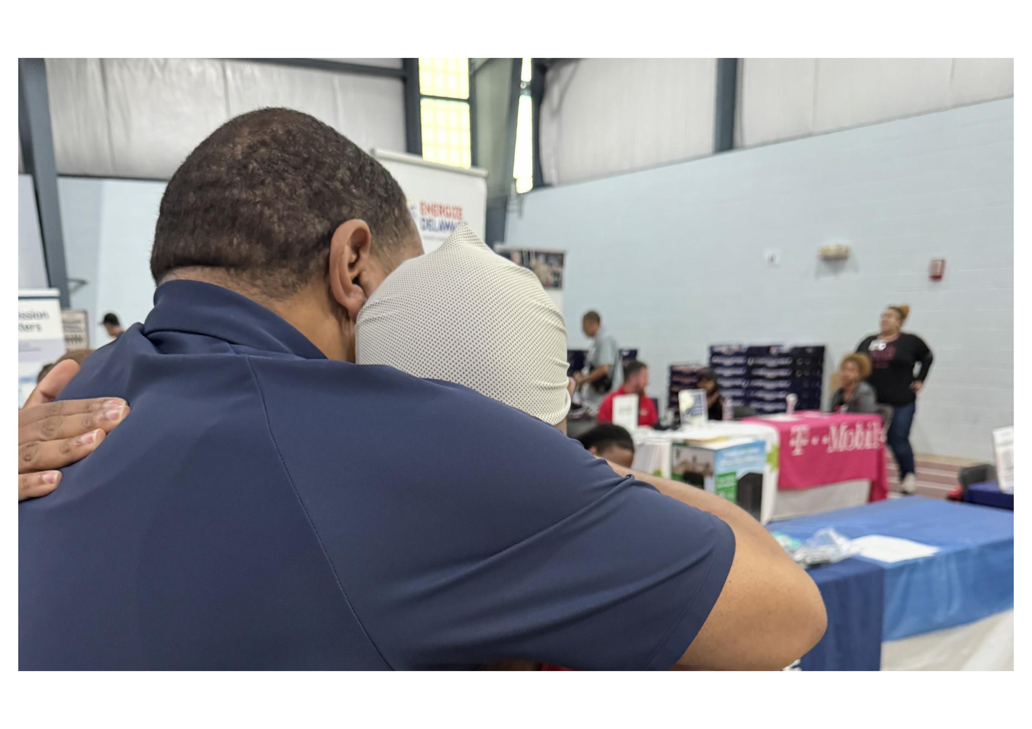 A warm moment at the Delaware Veterans Stand Down & Employment Expo as Devon Wilson shares a hug with a Delaware State University alum.