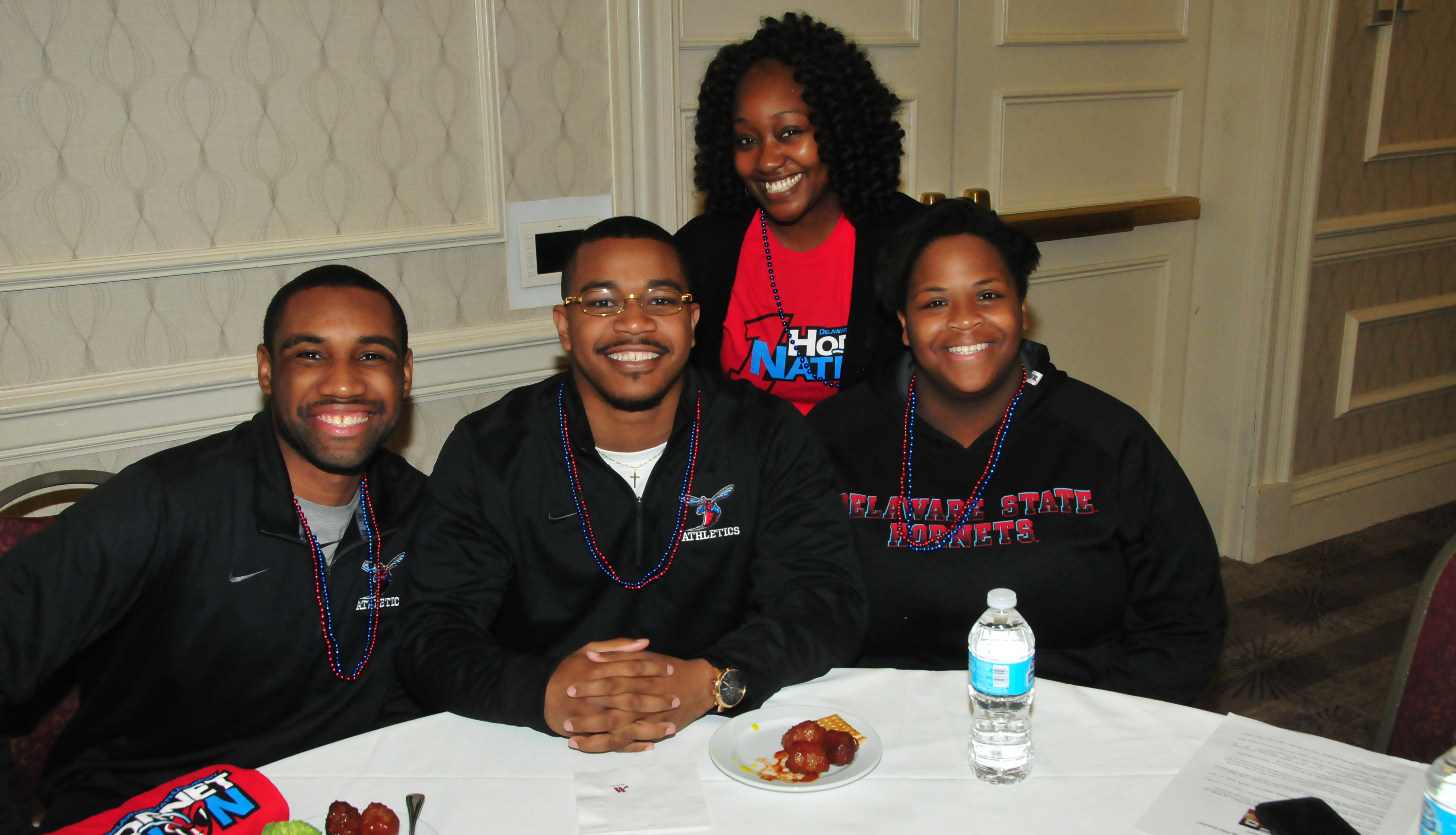 Diane Kirby (standing), manager of DSU Alumni Engagement, poses with three young alums at the March 9 DSU Alumni Reception at the MEAC Tournament in Norfolk, Va.