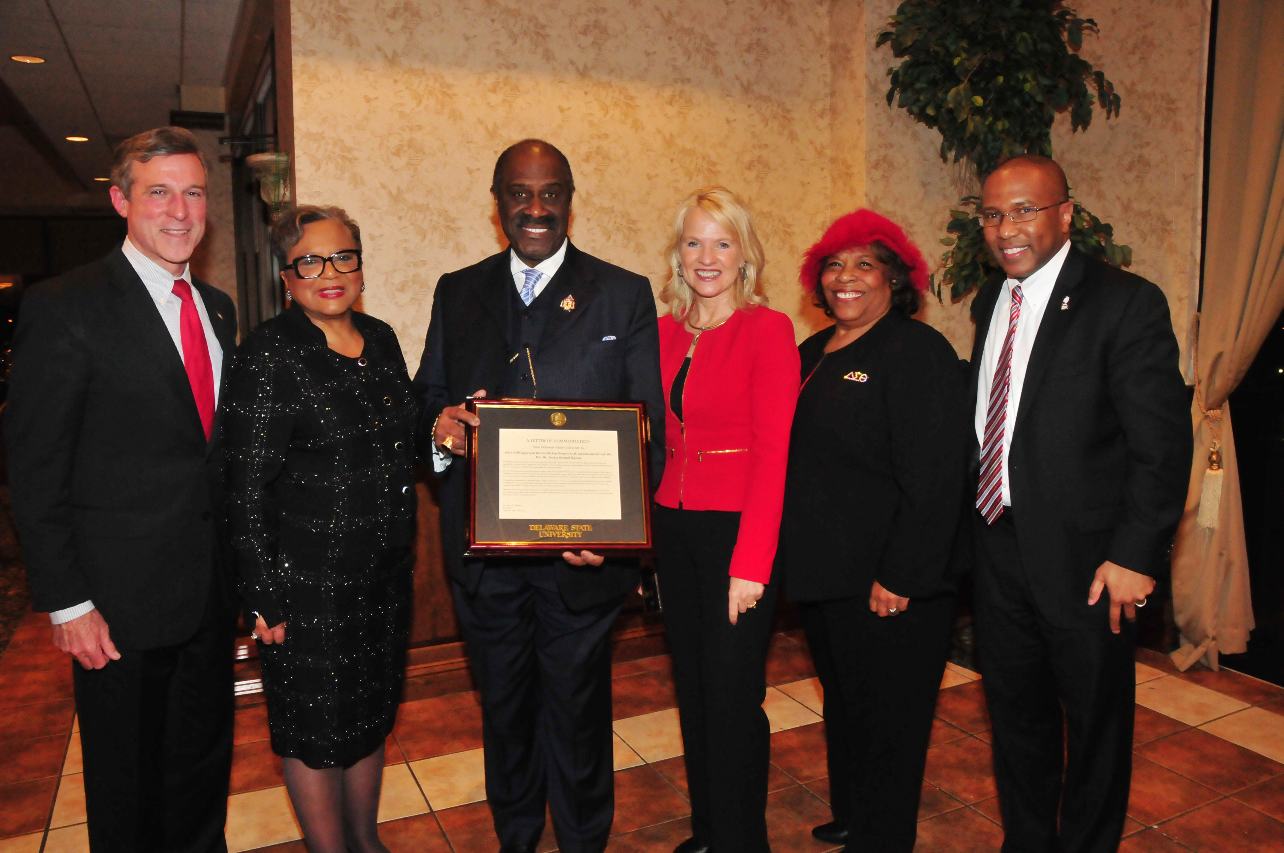 (L-r) Gov. John Carney, Rev. Dr. Jessica Kendall Ingram and her husband Bishop Gregory G.M. Ingram, Lt. Gov. Bethany Hall-Long, DSU Board of Trustees member Wilma Mishoe and DSU President Harry L. Williams, who presented the Ingrams with commendation from DSU.
