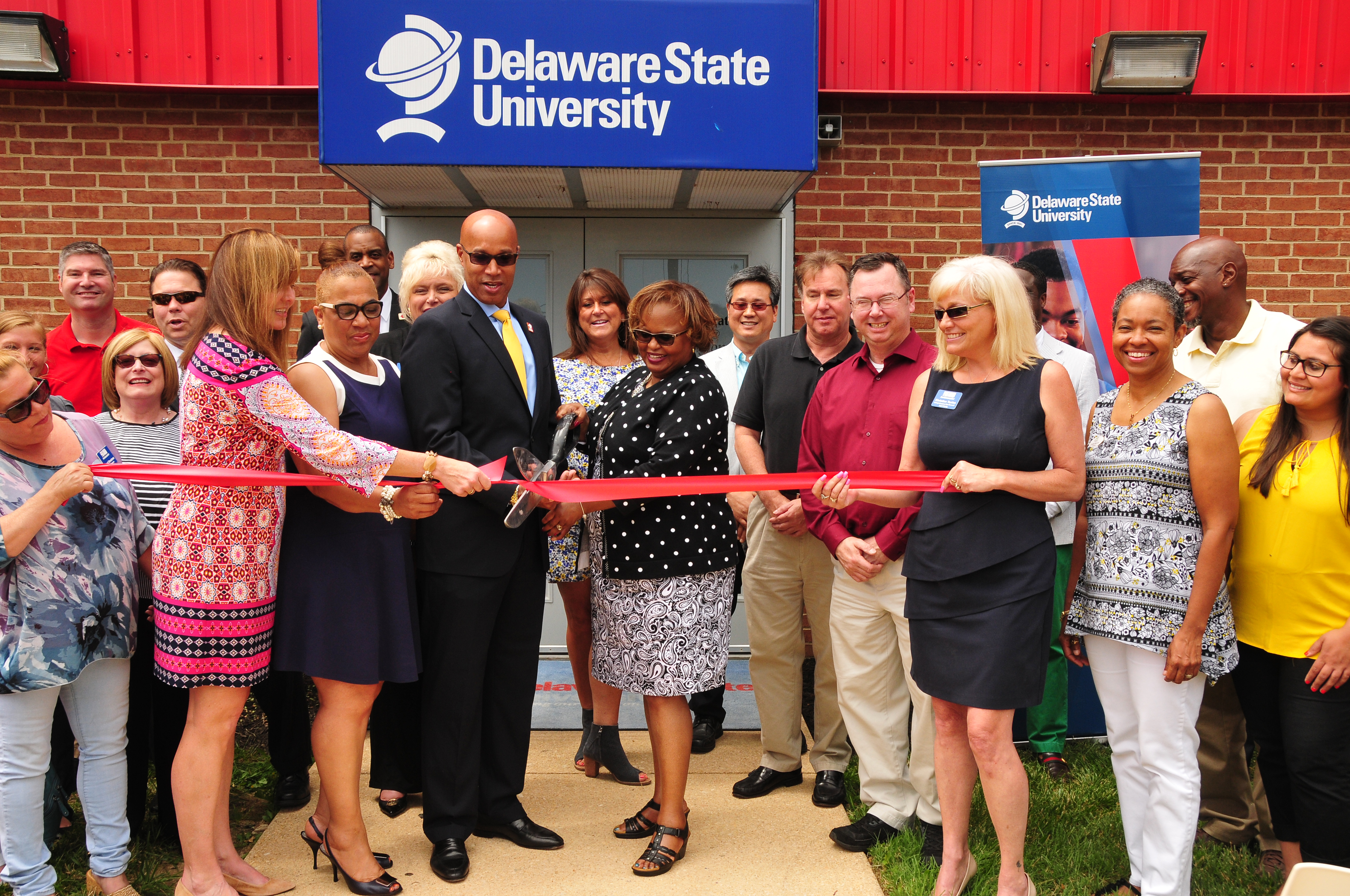 DSU Board of Trustees member Roy Roper and DSU Chief Financial Officer Teresa Hardee join officials of the New Castle County Chamber of Commerce for a ribbon cutting ceremony at the DSU@Wilmington location in recognition of its educational contribution to Northern Delaware.
