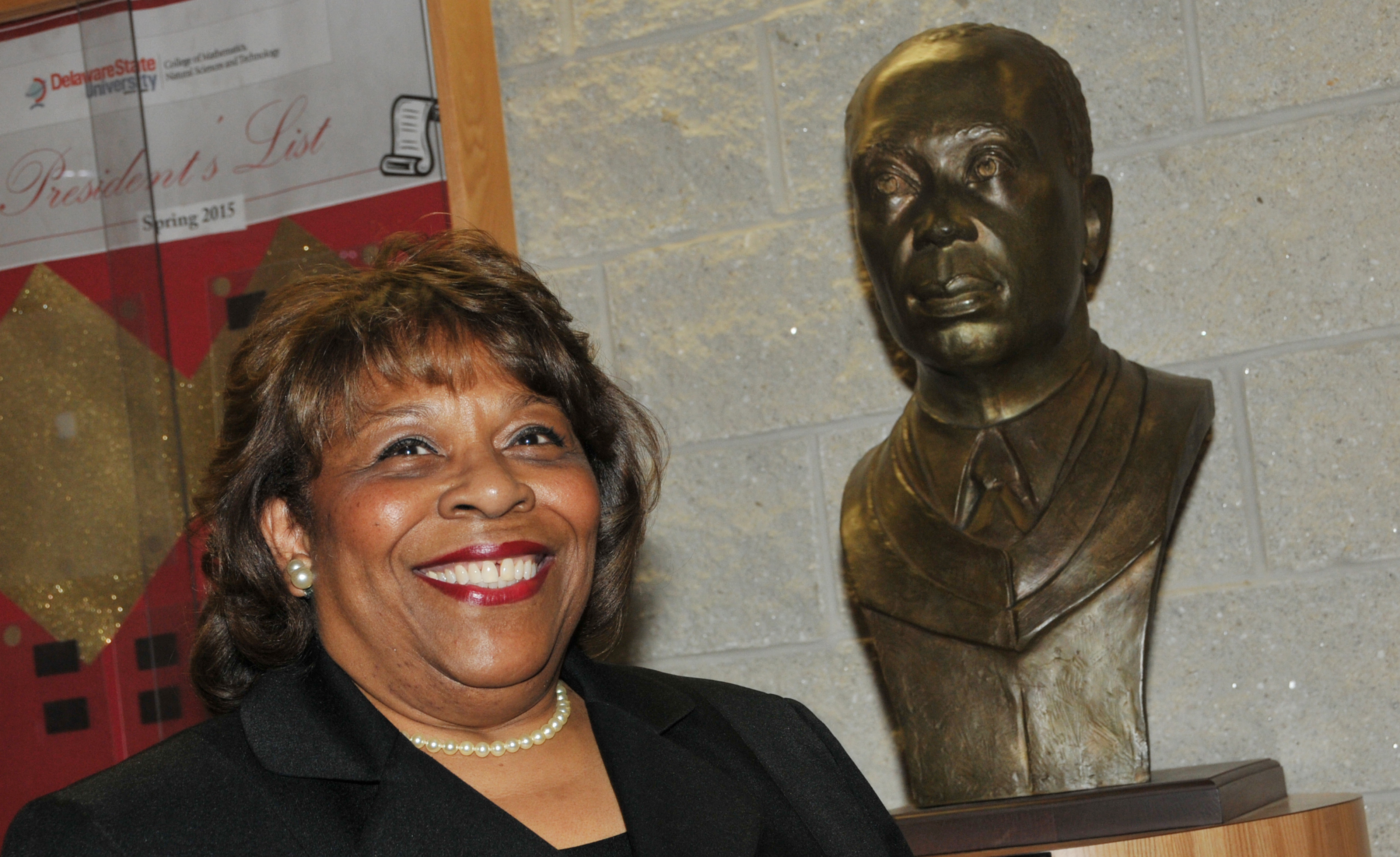 Dr. Wilma Mishoe, newly elected chairperson of the DSU Board of Trustees, stands next to the sculpture bust of her father Dr. Luna I. Mishoe, who was the president of then-Delaware State College from 1960-1987. Dr. Mishoe is the first woman to serve as the chair of the University's Board of Trustees.