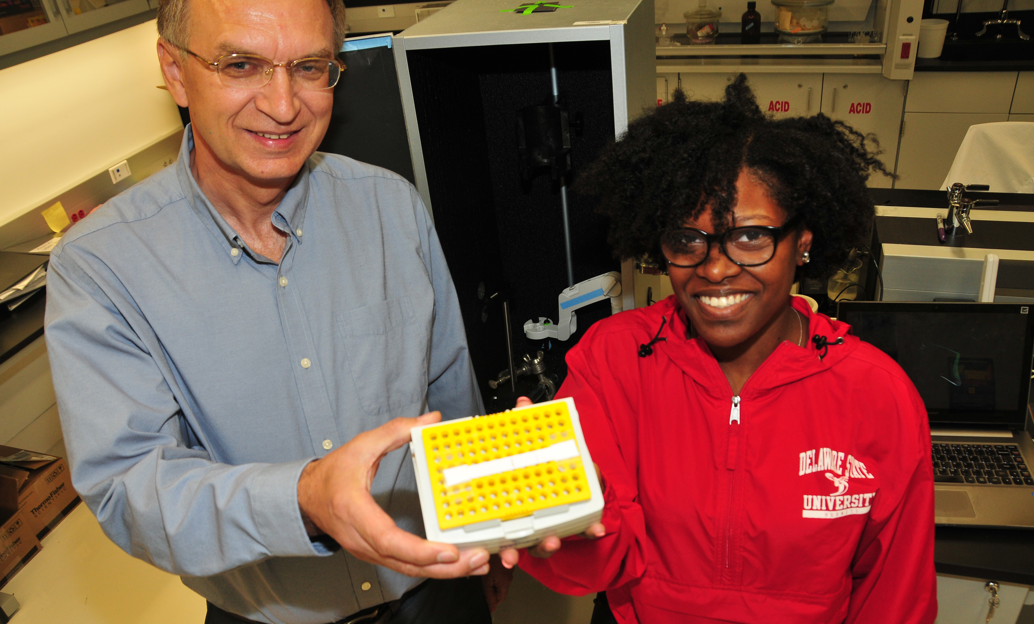 (L-r) Dr. Yuri Markushin, DSU physics researcher, and junior physics major Simone Johnson hold a pet strip invented here at DSU to help dog owners diagnose certain diseases in their pet and thereby save veterinarian costs.
