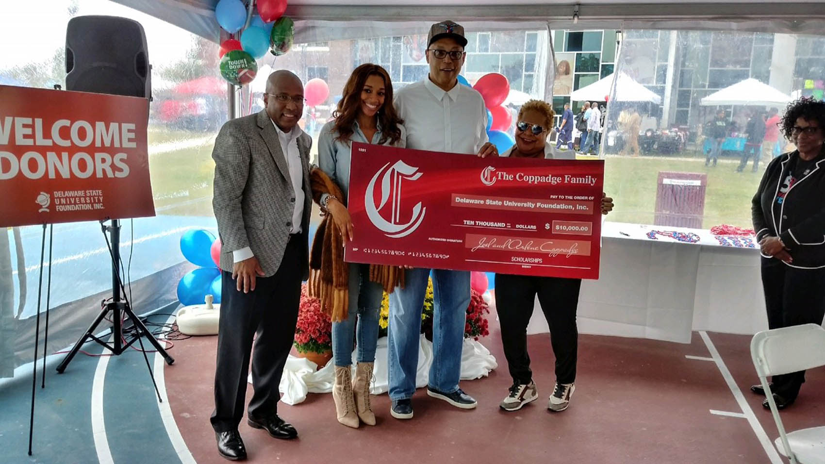 (L-r) DSU President Harry L. Williams, Alexandra Coppadge, and her parents Joel and Arlene Coppadge pose with a display check representing the scholarship endowment the couple has established.
