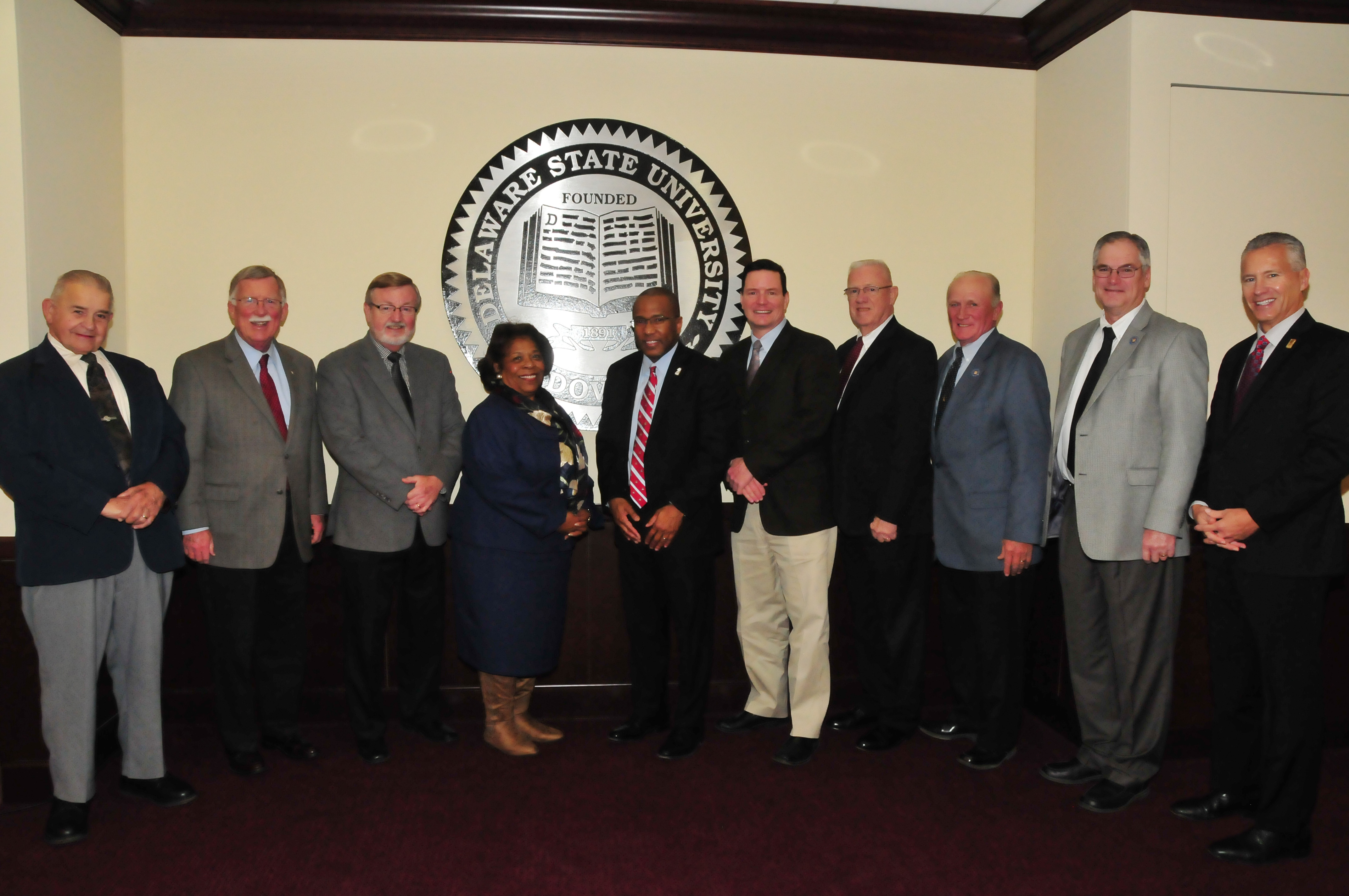 Dr. Harry L. Williams, joined by DSU Board of Trustees Chairwoman Dr. Wilma Mishoe, posed with a group of Kent County state legislators who held their final meeting with the outgoing DSU president on Dec. 12.