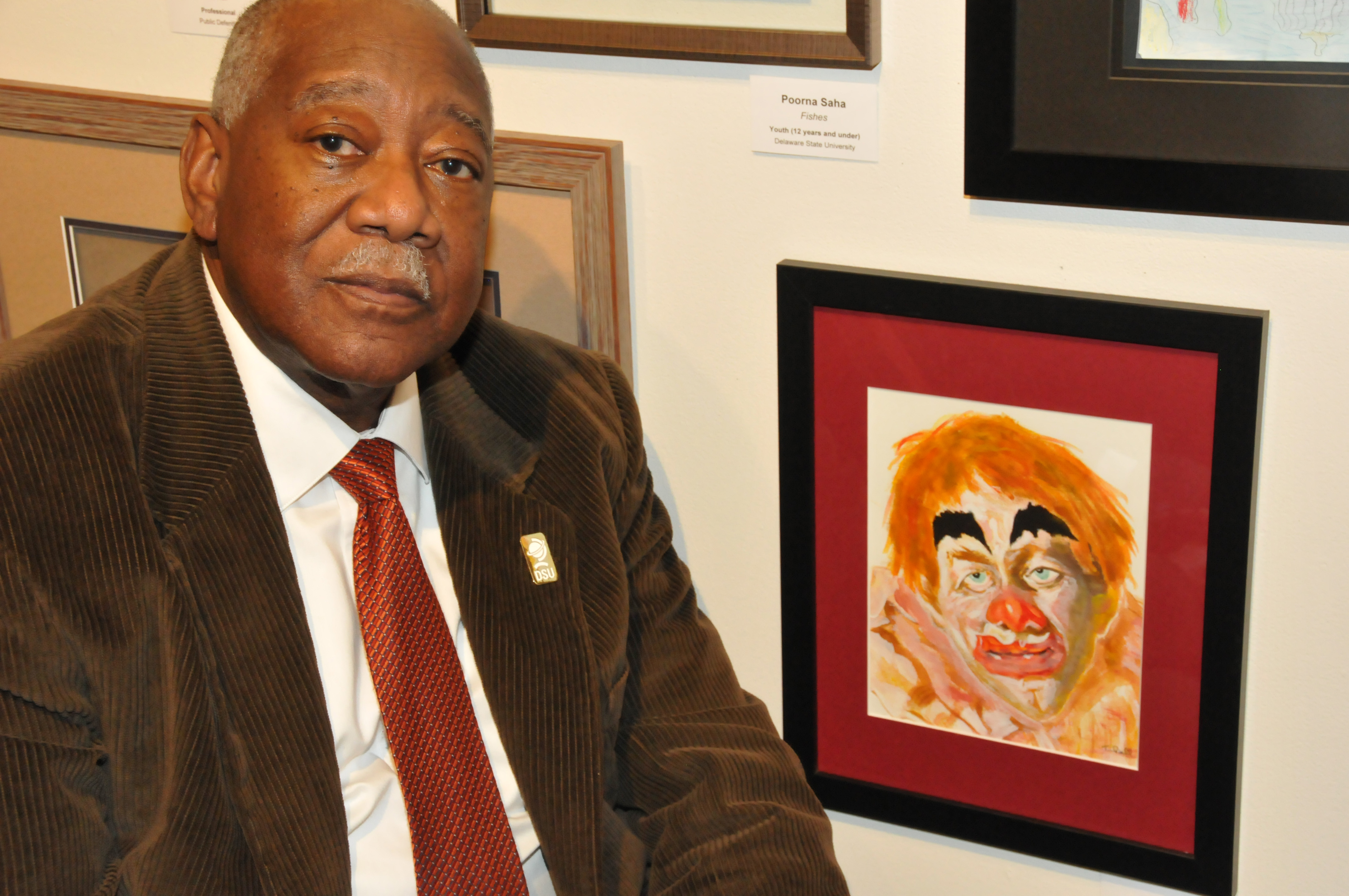 Bryant T. Bell with his artwork entitled "Barnum and Bailey Circus," one of the more than 200 works on display in the State Employee Exhibition in the Arts Center/Gallery on campus.