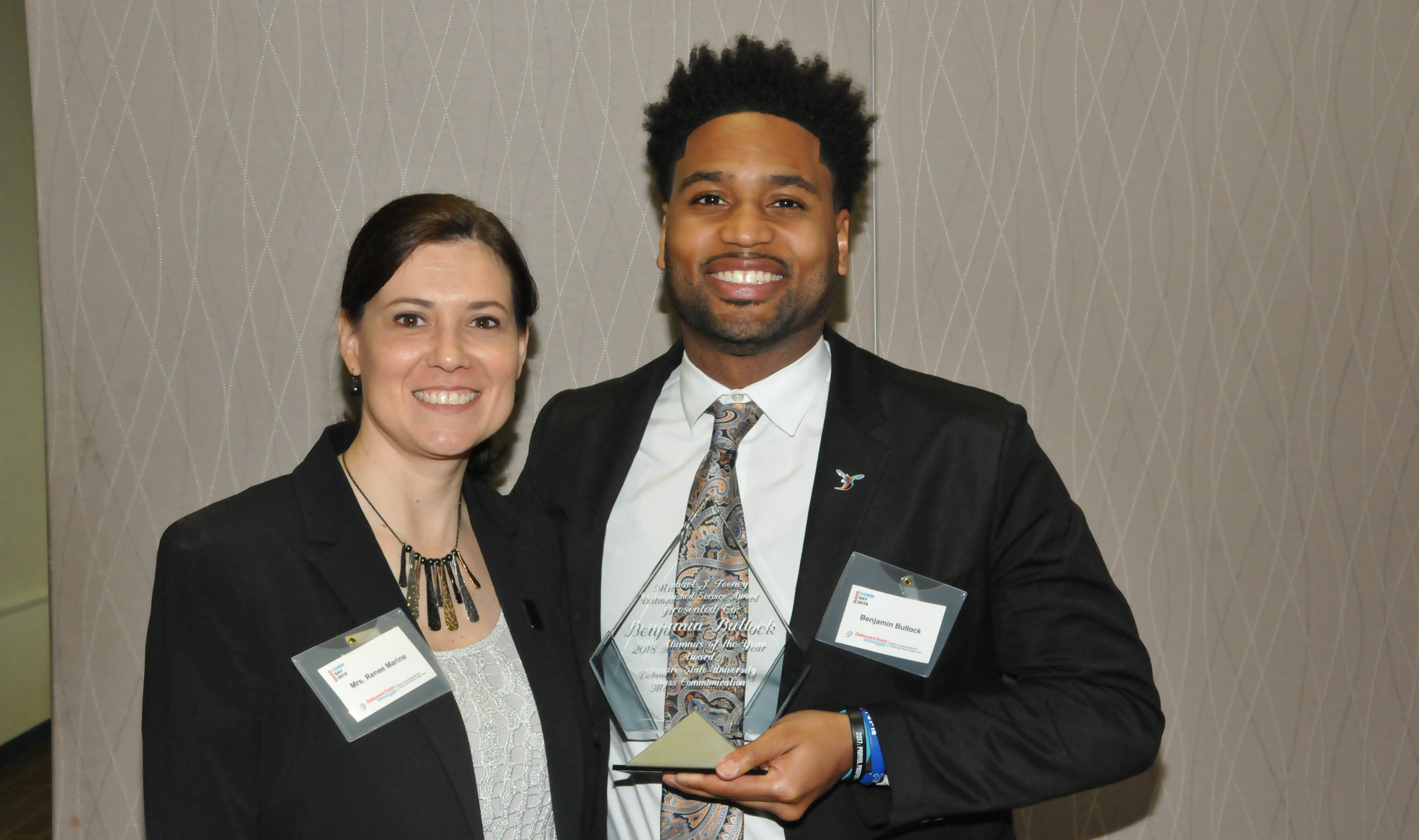 Ben Bullock, DSU Mass Comm Class of 2010, receives the Michael J. Feeney Outstanding Alumni Award from presenter Renee Marine, Mass Comm program coordinator.