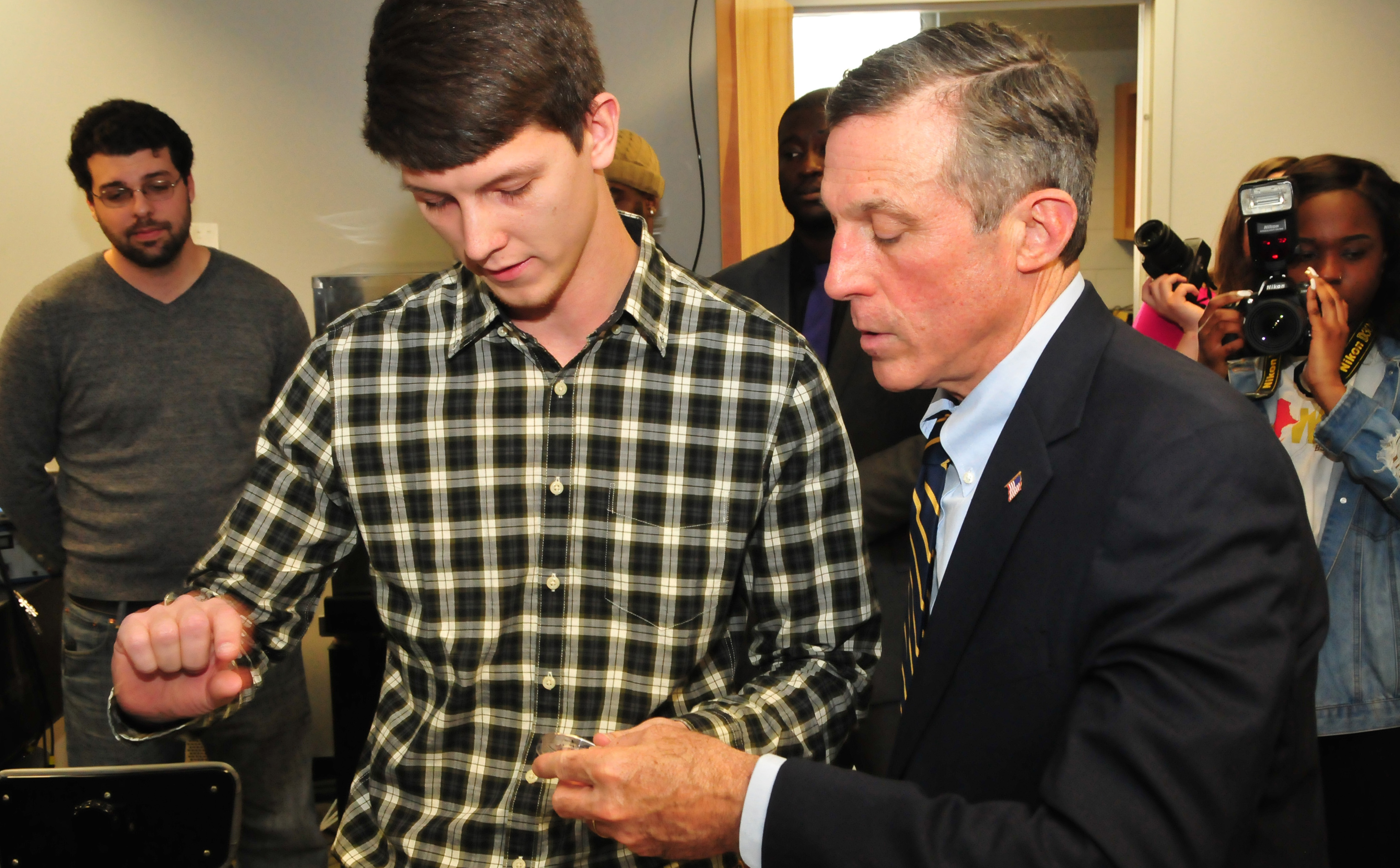 Andrew Voshell (l), graduate engineering students, shows Gov. John Carney a materials sample that is part of some current analytical research he is involved with at DSU.