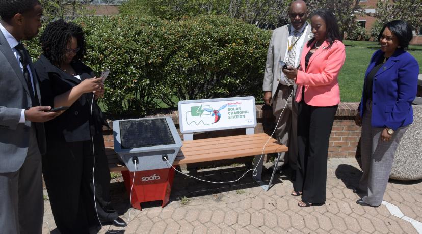 <p>Some University employees try out one of the new solar benches installed outside of the William C. Jason Library and the Mishoe Science Center.</p>
